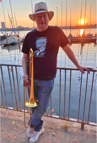Jerry Tilitz stands next to the Alster lake with his trombone